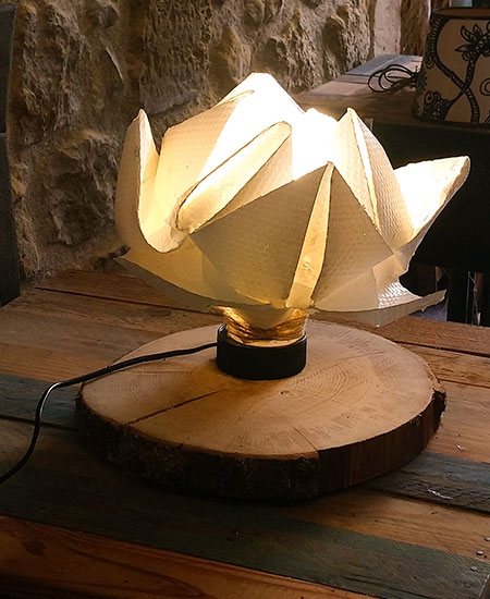Lampe origami fleur de lotus sur tranche de bois