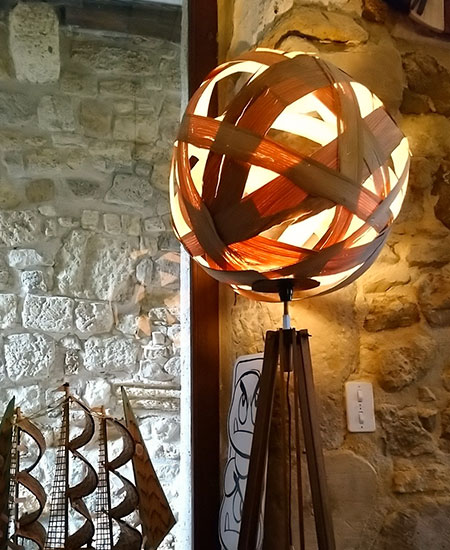 Lampe abat-jour sphère en lamelles de bois allumée