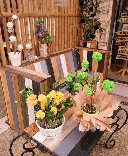 Pomponnettes de fleurs en extérieur disposés sur une table et un banc