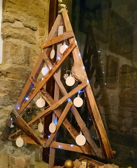 Sapin en bois de récupération décoré avec boules en tranches de bûchettes et petite guirlande